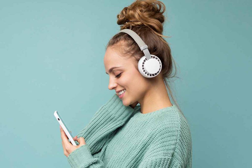 persona che ascolta musica con cuffie wireless da smartphone