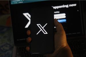 logo piattaforma X su smartphone e PC