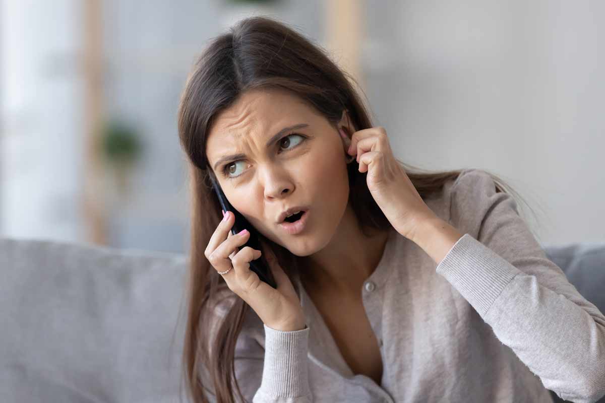 donna al telefono in casa che fatica a sentire l'interlocutore per scarso segnale
