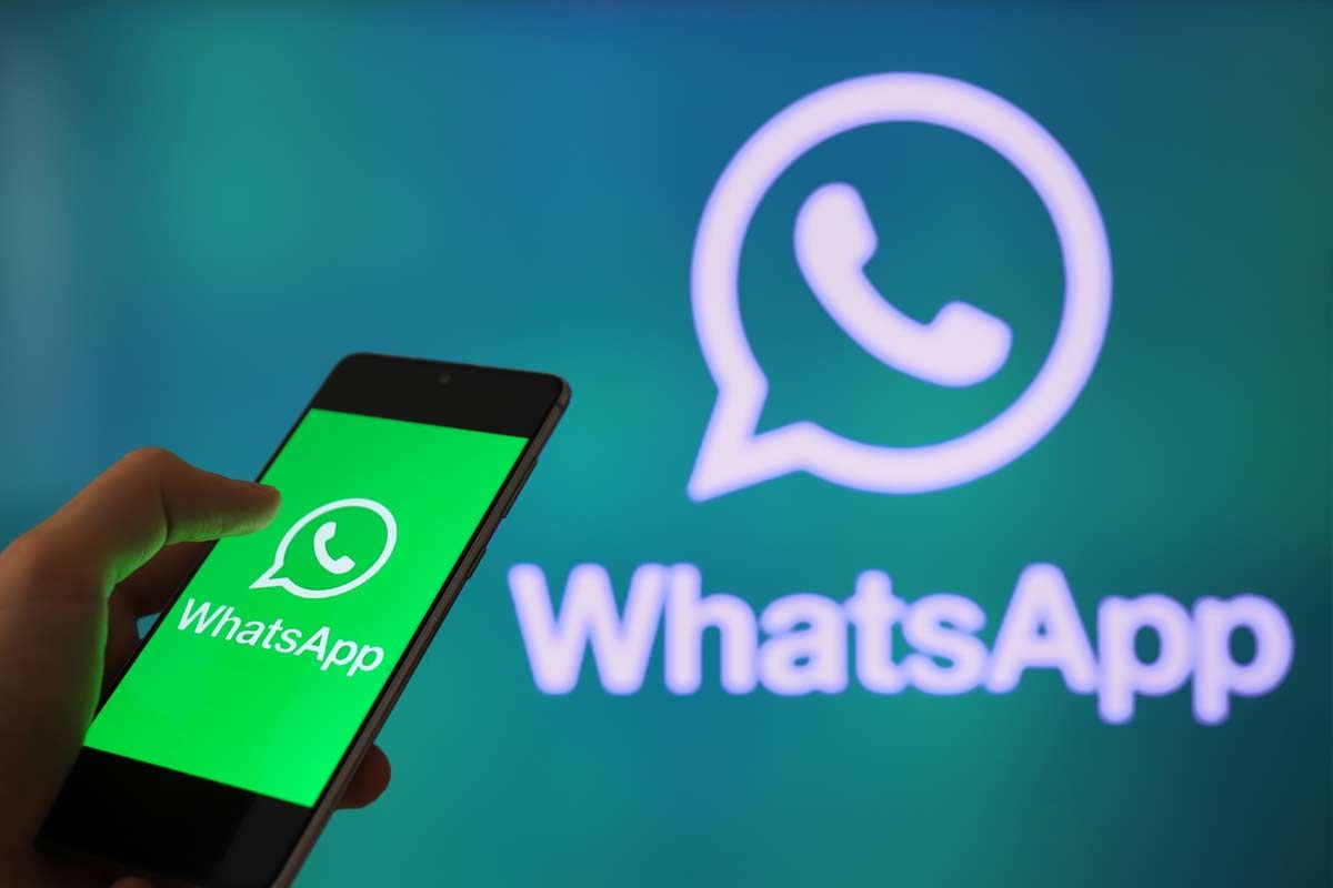 logo WhatsApp luminoso e su schermo smartphone