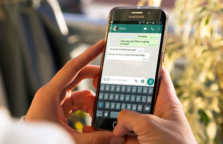 persona scrive su WhatsApp con smartphone