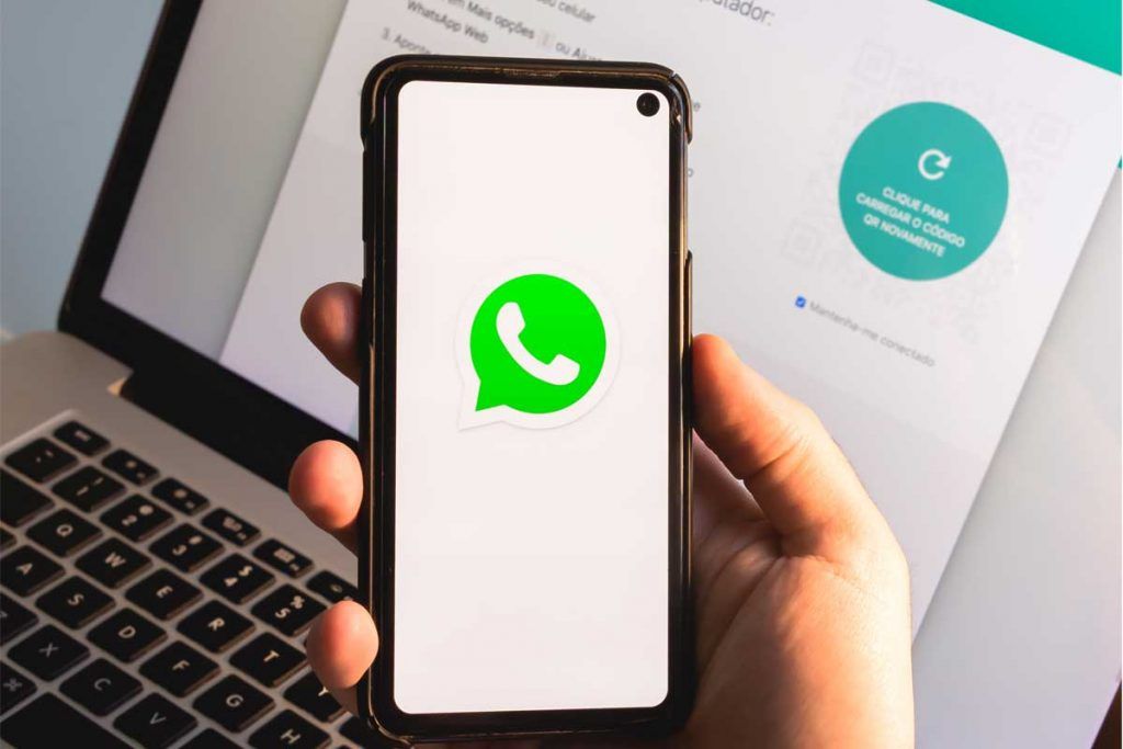 WhatsApp - icona app su smartphone davanti a pc