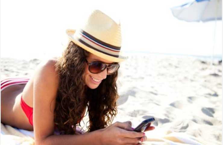 Ragazza utilizza il telefono al mare