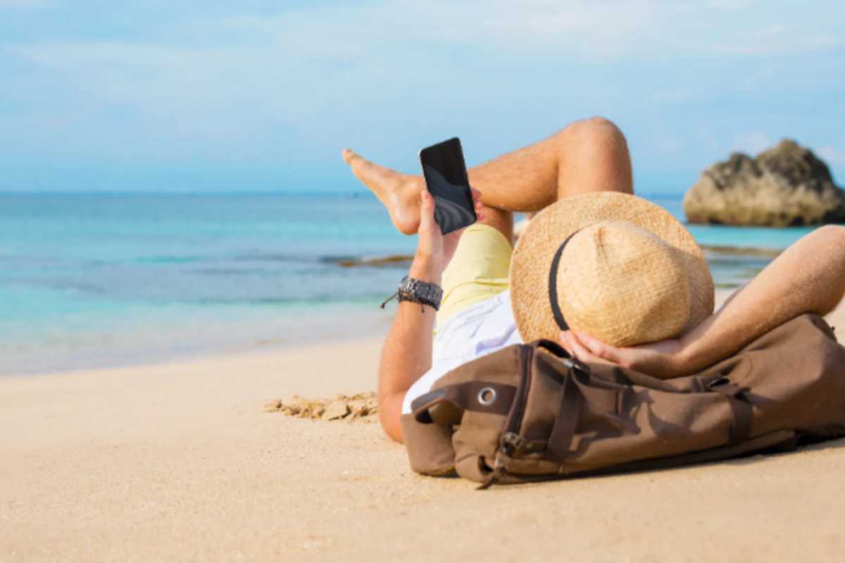 Ragazzo utilizza l'iPhone in spiaggia